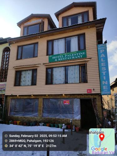 a building with a sign on the front of it at Hotel Palestine in Pahalgām