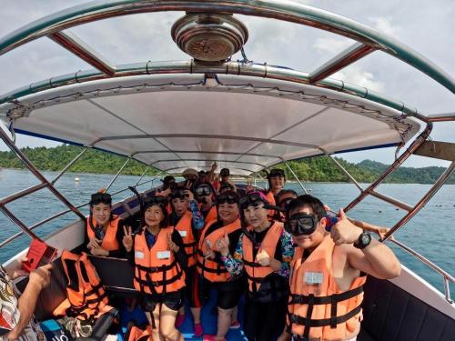 a group of people in orange life jackets on a boat at Lungkluay homestay in Ko Kood