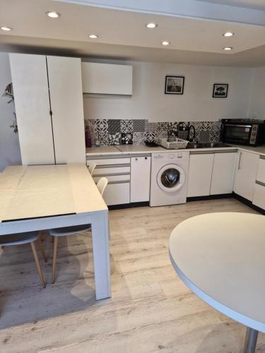 una cucina con mobili bianchi e un tavolo di Appartement moderne a Payns