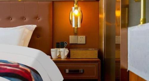 a bedroom with a bed and a nightstand with a white bedspread at James Joyce Coffetel·Lijiang Old Town Centeral in Lijiang