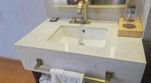 a bathroom with a sink and a counter with towels at James Joyce Coffetel·Lijiang Old Town Centeral in Lijiang