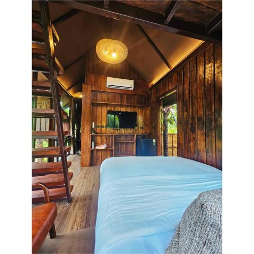 Ban Tha MaphraoにあるCheewatra Farmstay Coconut Houseのベッドルーム1室(ベッド1台、二段ベッド付)