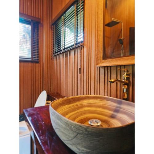 Ban Tha MaphraoにあるCheewatra Farmstay Coconut Houseのバスルーム(テーブルの上に大きな木製バスタブ付)