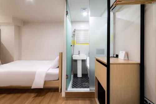 1 dormitorio con cama y lavamanos en ZIYOLK Myeongdong, en Seúl