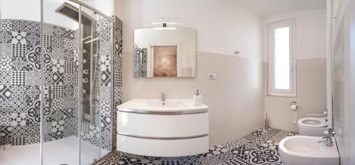 a white bathroom with a sink and a toilet at La rosa dei venti in Santa Margherita Ligure