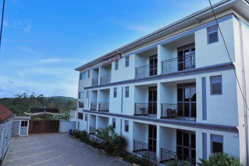a white building with balconies on the side of it at Primland Hotel Buyala in Buloba