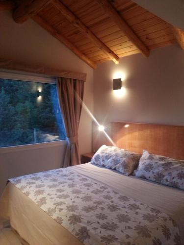 a bedroom with a large bed with a window at Laderas Verdes in Esquel