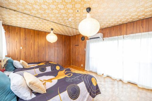 a bedroom with a bed and two pendant lights at Lax奈良 奈良観光に便利な和モダン古民家 最大12名 グループや家族旅行に最適 in Nara