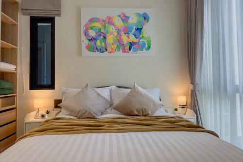 a bedroom with a bed with two lamps and a painting at Title Halo Naiyang 1BR Apart Garden View bar table in Nai Yang Beach