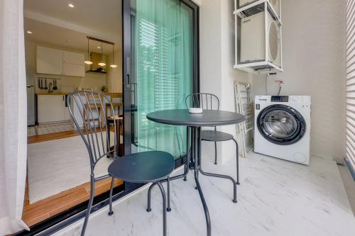 a table and chairs in a kitchen with a washing machine at Title Halo Naiyang 1BR Apart Garden View bar table in Nai Yang Beach
