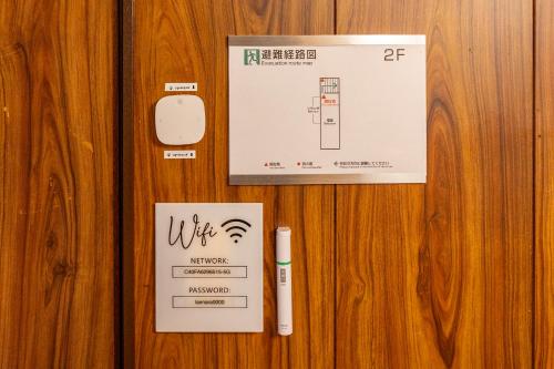 a wooden door with a sign and a thermometer and a pen at Lax奈良 奈良観光に便利な和モダン古民家 最大12名 グループや家族旅行に最適 in Nara