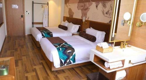 a hotel room with two beds and a sink at James Joyce Coffetel Shenyang North Railway Station Qishan Road Metro Station in Shenyang