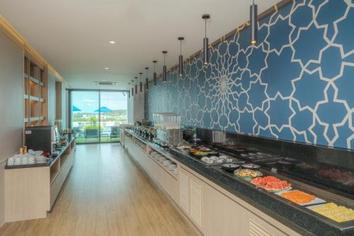 a buffet line in a restaurant with many plates of food at The Yama Hotel Phuket in Kata Beach