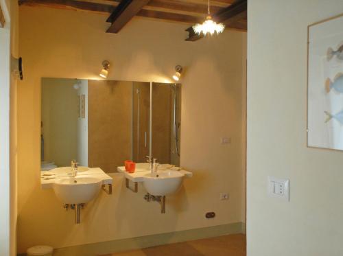 a bathroom with two sinks and a large mirror at La Doccia in Anghiari