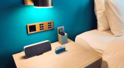 a bedroom with a bed and a desk with a speaker at Zhuhai Hongsanyi Hotel in Zhuhai