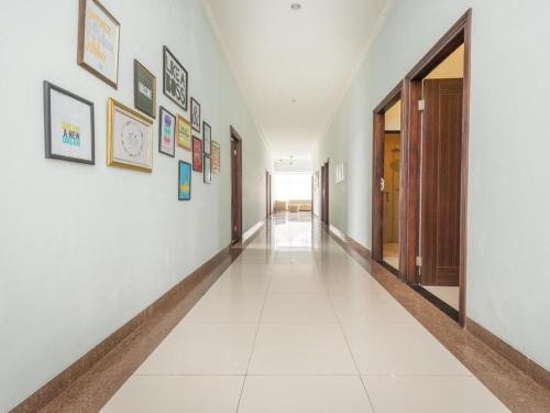 a hallway with white walls and pictures on the walls at The Studio Inn Nusa Dua in Ubud