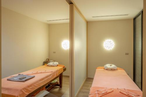 a room with two beds and a mirror at The Yama Hotel Phuket in Kata Beach