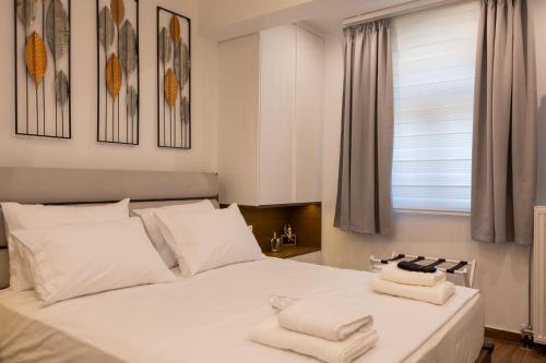 a bedroom with a white bed with towels on it at The Monolith in Kalabaka