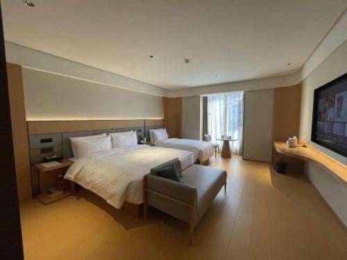 a bedroom with two beds and a flat screen tv at 7 Days Inn Zhangjiakou Chongli Yuxing Road in Zhangjiakou