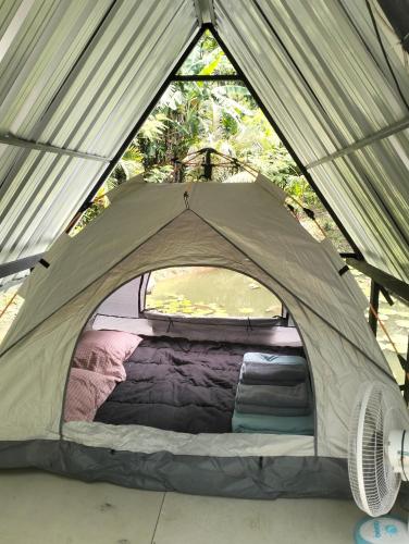 a tent with a bed inside of it at บ้านเล็กในป่าใหญ่ พัทลุง in Ban Nai Mon