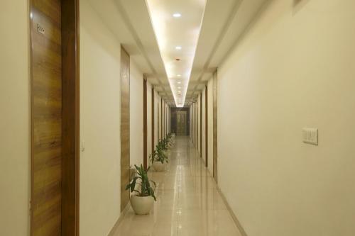 a hallway with potted plants in a building at Hotel The Prithvi Near Delhi Airport in New Delhi