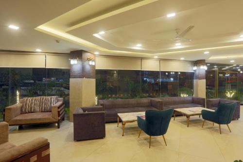 a lobby with couches and chairs and tables at Hotel The Prithvi Near Delhi Airport in New Delhi