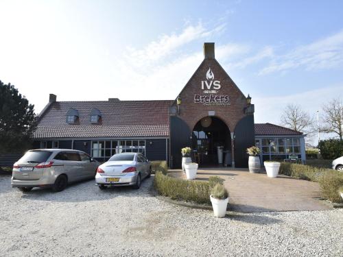 two cars parked in a parking lot in front of a building at Studio Hazenborgh in Callantsoog near the sea in Callantsoog