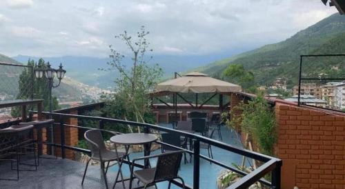 a balcony with a table and chairs and a view at The Pema by Realm in Thimphu