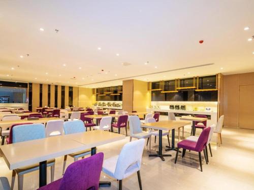a dining room with tables and purple chairs at Lavande Hotels· Guizhou Anshun Xi Railway Station in Anshun