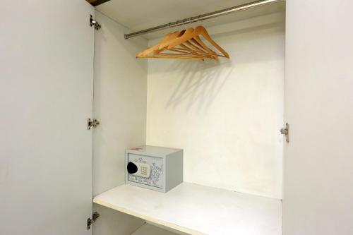a closet with a shelf with a clock on it at Hotel Cardinal Express Oxmo Delhi Airport in New Delhi