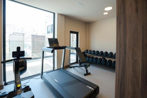 a gym with a treadmill and a large window at Zenit Borrell in Barcelona