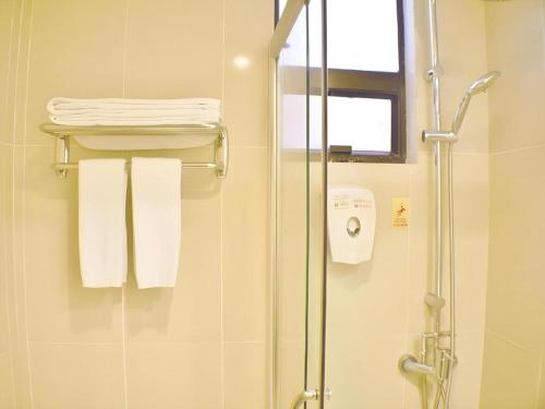 a bathroom with a shower with white towels at London Hotel in Macau