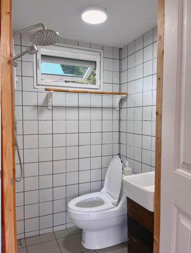a bathroom with a toilet and a sink and a window at Silver Oak Valley บ่อเกลือสะปัน น่าน in Ban Kham