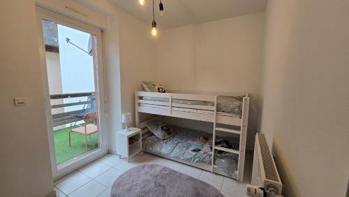 Chez Mar'tine 2 في نيديربرون ليه باينس: غرفة نوم بها سرير ونافذة كبيرة