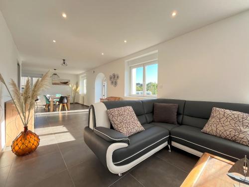 a living room with a couch and a dining room at Maison spacieuse pour 8 personnes, proche GR34 in Sibiril