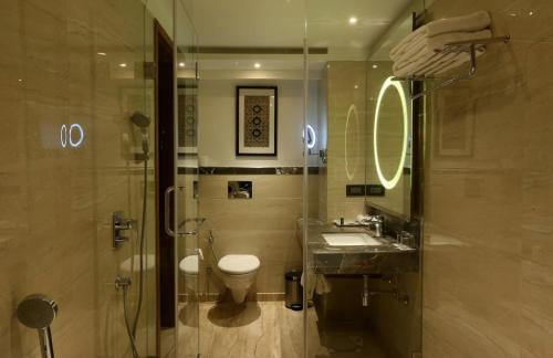 a bathroom with a toilet and a sink and a shower at Hotel The Prithvi Near Delhi Airport in New Delhi
