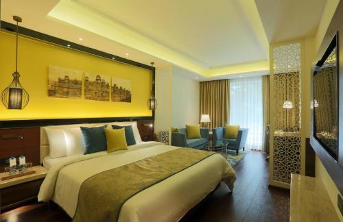 a hotel room with a large bed and a living room at Hotel The Prithvi Near Delhi Airport in New Delhi