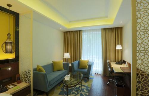 a living room with a couch and chairs and a table at Hotel The Prithvi Near Delhi Airport in New Delhi