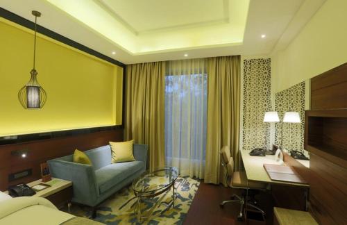 a hotel room with a bed and a desk and a chair at Hotel The Prithvi Near Delhi Airport in New Delhi
