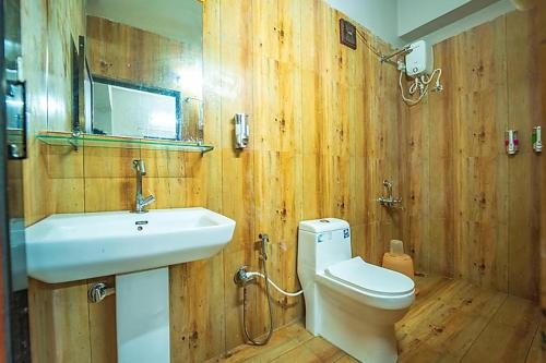 a wooden bathroom with a sink and a toilet at Cayana Palms in Sāhān