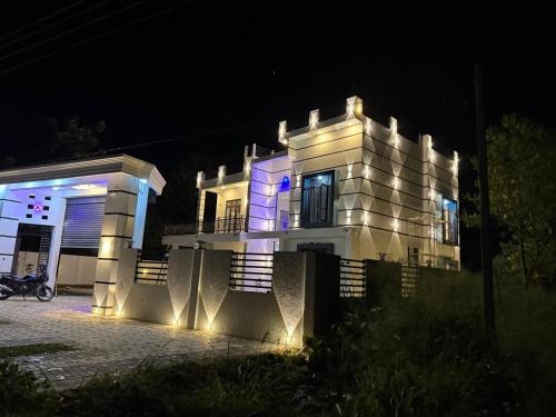 a large white building with lights on it at night at Geeth Wild Resort in Tanamalwila