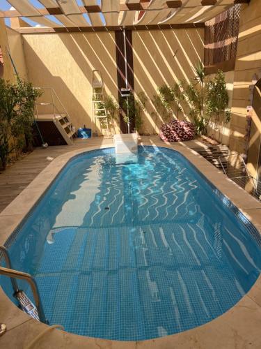 a large blue swimming pool in a building at luxury dublex with private swimming pool in Obour