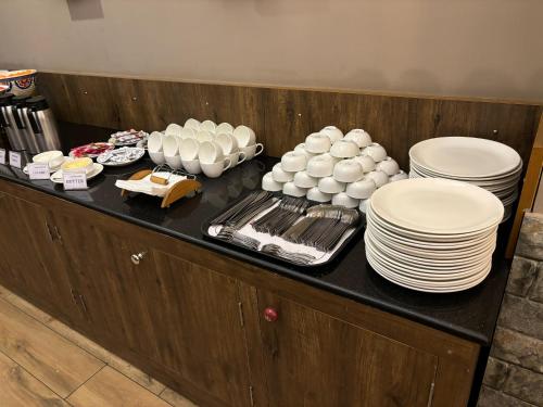 a buffet with plates and dishes on a table at Hotel Cardinal Express Oxmo Delhi Airport in New Delhi
