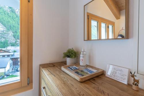 a bathroom with a mirror and a wooden counter at Comfortable apartment for 4-8 persons near Zermatt in Täsch