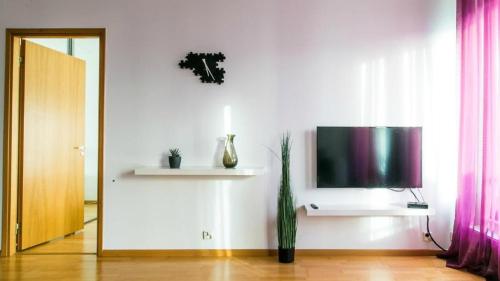 a living room with a flat screen tv on a wall at Easty Stay Apartments - City Centre in Tallinn