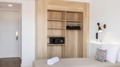 a bedroom with a bed and a wall with a microwave at htop Amatista #htopBliss in Lloret de Mar