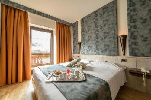 a hotel room with a tray of food on a bed at Hotel Comtes De Challant in Fenis