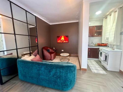 a living room with a blue couch and a kitchen at Kampala Studio with Lake Breeze in Kampala