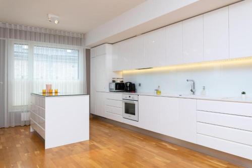 a kitchen with white cabinets and a counter top at Easty Stay Apartments - City Centre in Tallinn