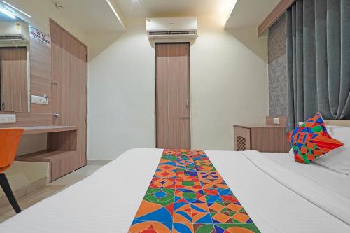 a bedroom with a bed with a colorful blanket on it at FabHotel New Empire in Ahmedabad